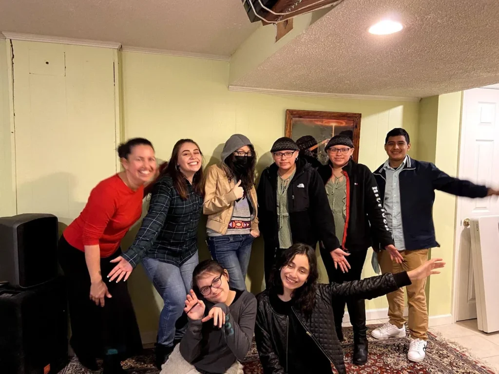 Grupo de jóvenes posa con gestos divertidos junto a una líder