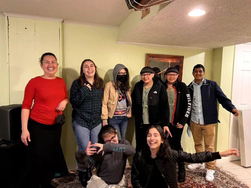 Grupo de jóvenes riendo y posando con alegría junto a una líder